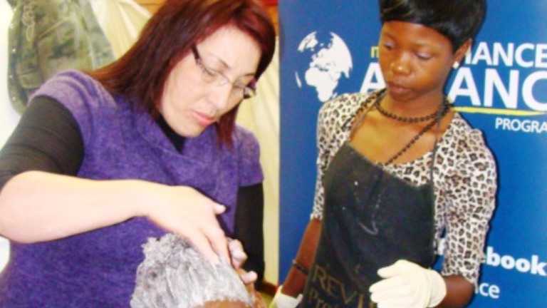 Facilitator Nina Eckersley demonstrating the correct procedure to apply relaxer in the Introduction to Hairdressing workshop